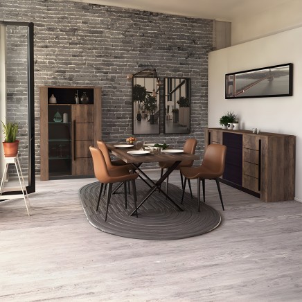 Comedor moderno con mesa redonda madera y sillas tapizadas caramelo junto a muebles de almacenamiento en madera y pared de ladri