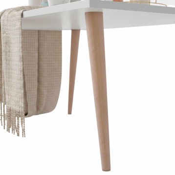 Mesa redonda blanca con patas de madera clara y manta beige colgada en el lateral