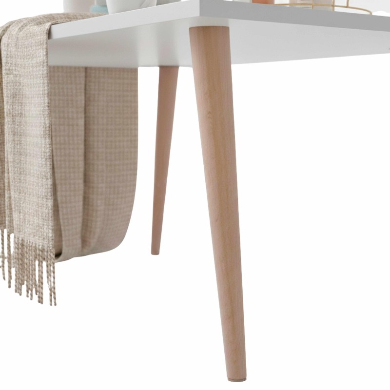 Mesa redonda blanca con patas de madera clara y manta beige colgada en el lateral