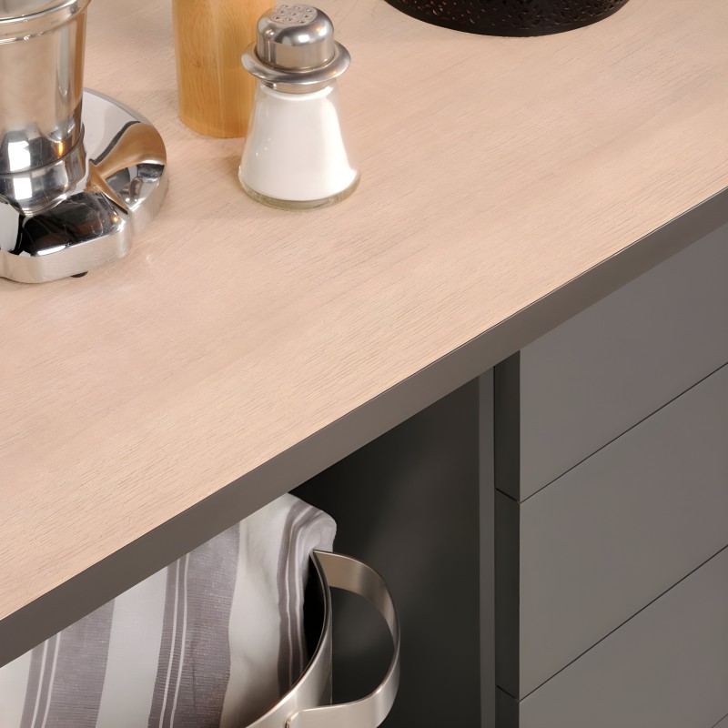 Detalle de encimera de cocina en madera clara con base gris y accesorios de cocina
