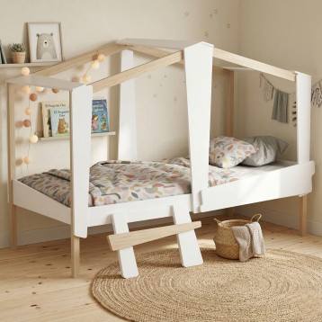Cama infantil dosel madera natural y blanco con almohadas y ropa de cama estampada