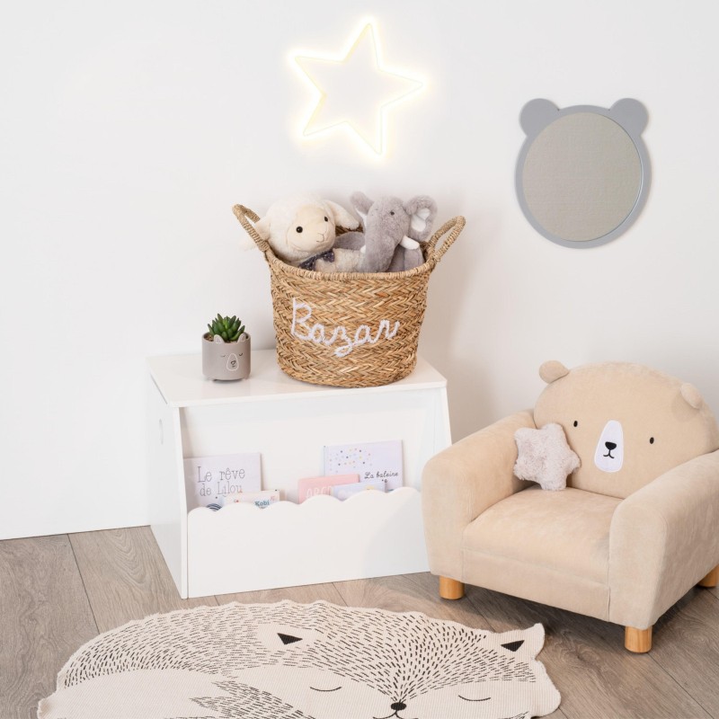Sillón infantil beige con patas de madera y juguete de peluche en habitación de bebé