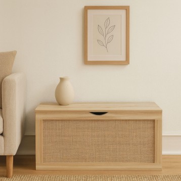 Baúl de madera clara con panel de rejilla y cajón frontal en ambiente de salón junto a sillón beige