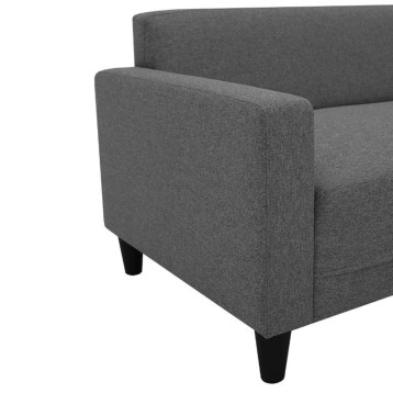 Sofa tapizado en tela gris oscura con brazos altos y patas negras vista de detalle lateral