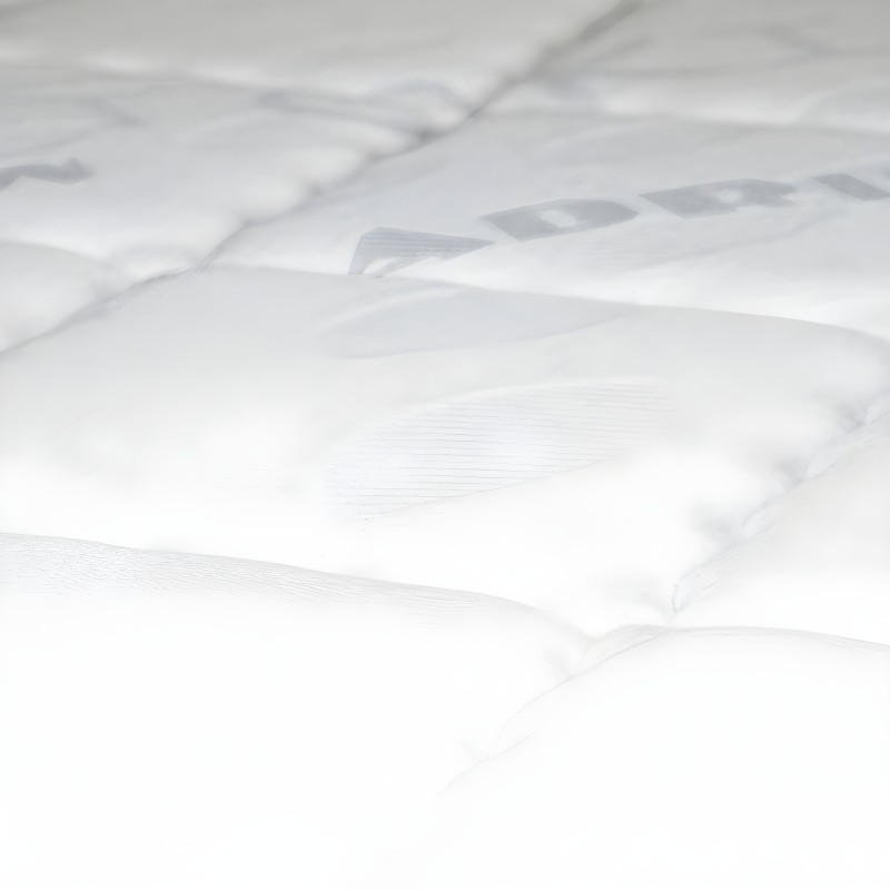 Detalle de colchón acolchado blanco con superficie mullida y costuras decorativas