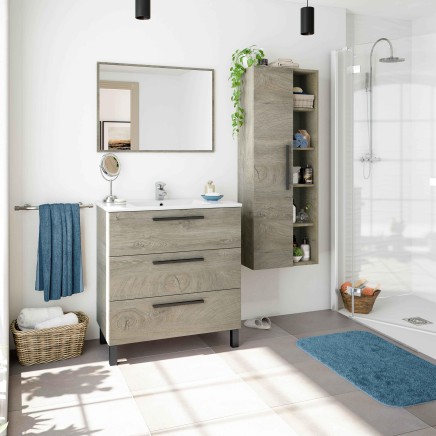 Conjunto de baño en madera clara con mueble bajo de tres cajones y columna con compartimentos abiertos en ambiente de ducha