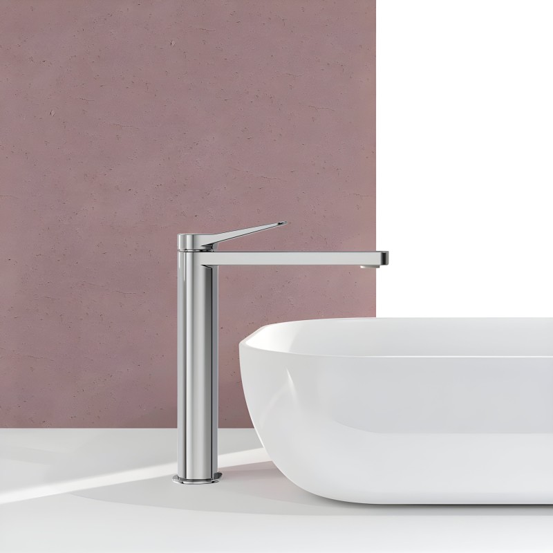 Grifo de baño monocomando alto en cromo pulido junto a lavamanos blanco en ambiente de baño moderno