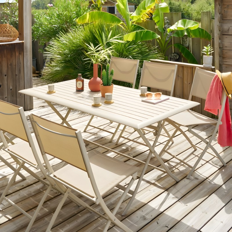 Conjunto de jardín con mesa rectangular blanca y sillas de lona beige en terraza de madera rodeada de plantas verdes