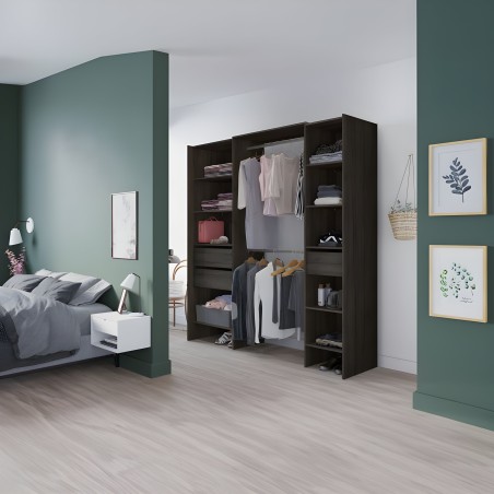 Armario modular negro con puertas abiertas y compartimentos para ropa y accesorios en dormitorio con pared verde