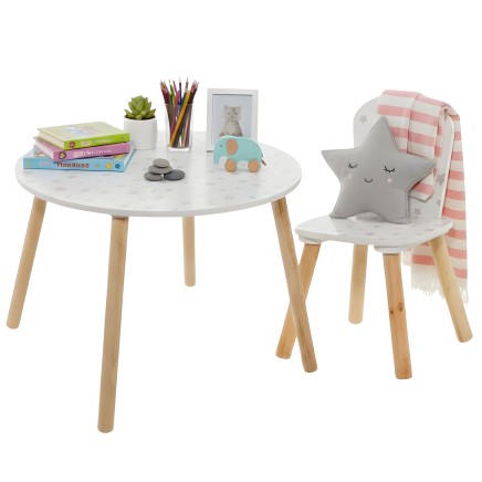 Conjunto infantil con mesa redonda blanca y patas madera y silla gris con respaldo en forma de estrella y manta rosa