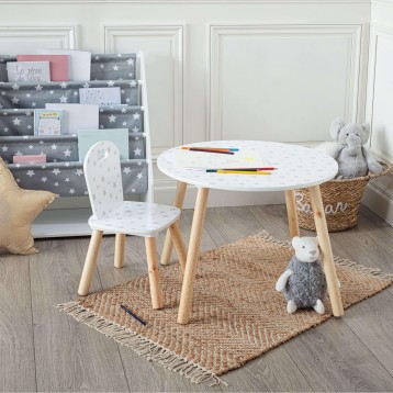 Mesa infantil redonda blanca con patas madera y silla a juego en habitación infantil