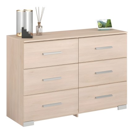 Cómoda de madera clara con 6 cajones y tiradores metálicos en ambiente de dormitorio