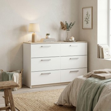 Cómoda blanca con seis cajones y tiradores plateados en dormitorio moderno y luminoso