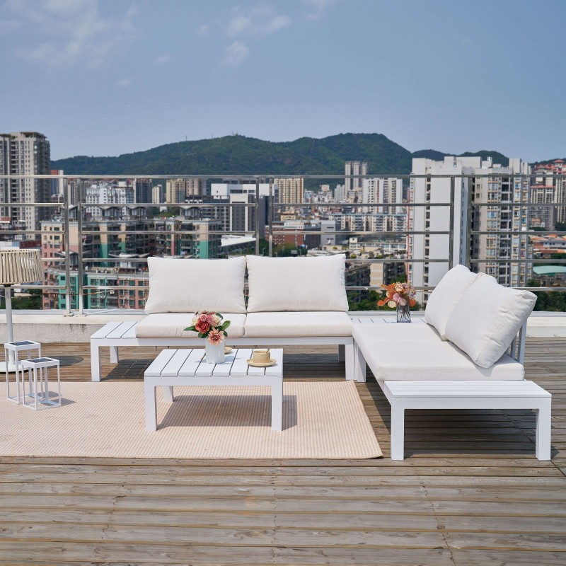 Conjunto de sofá modular blanco con cojines y mesa de centro en terraza con vistas a ciudad y montañas