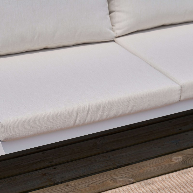 Sofá en tela blanca cruda con cojines y estructura de madera oscura detalle de asiento y respaldo