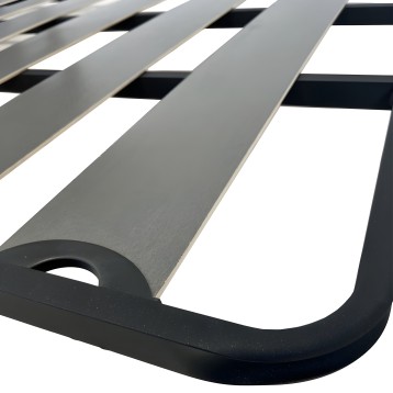 Sommier tapizado gris con estructura de listones blancos y base negra en detalle de construcción
