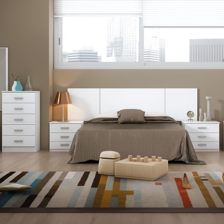 Dormitorio completo con cama de madera y cabecero tapizado blanco junto a mesitas y cómoda blanca a juego
