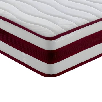 Detalle de colchón con capas visibles blanco y burdeos con superficie acolchada y bordes ribeteados