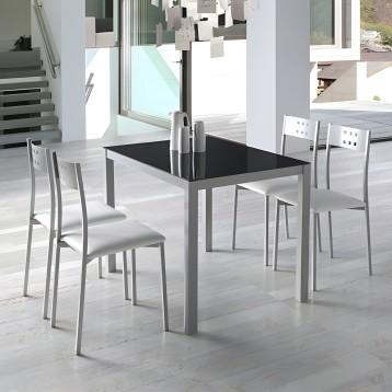 Conjunto de comedor con mesa rectangular de tapa negra y estructura gris y sillas blancas en ambiente moderno