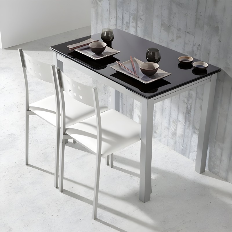 Mesa alta de comedor con tablero negro y estructura blanca acompañada de dos sillas altas blancas en ambiente minimalista