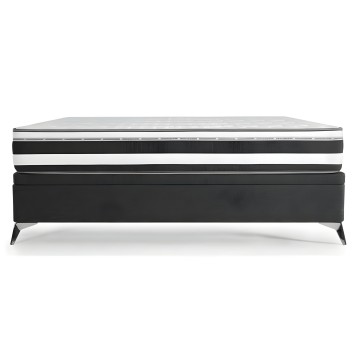 Cama con base tapizada en negro y colchón viscoelástico con capas de espuma y núcleo de muelles