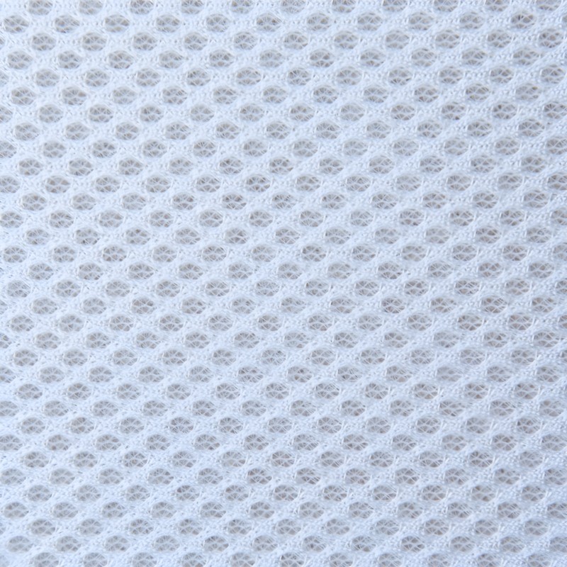 Detalle de tejido tapizado color blanco crema con textura de malla transpirable y trama geométrica