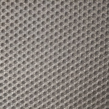 Detalle de tapicería gris claro con textura acolchada y patrón de puntos en relieve