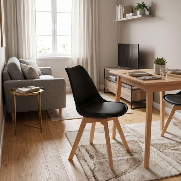 Silla moderna con asiento negro y estructura de madera clara en ambiente de oficina y sala de estar