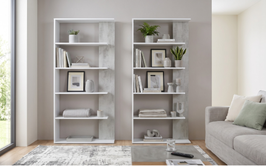 Estantería blanca de cinco baldas con laterales efecto cemento, decorada con libros y plantas en salón luminoso