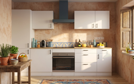 Cocina blanca moderna con muebles altos y bajos, horno integrado y detalles decorativos mediterráneos